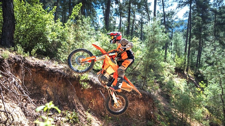 Person riding KTM dirt bike in the woods