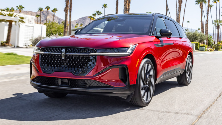 Front quarter view of a red 2024 Lincoln Nautilus on a palm tree-lined street