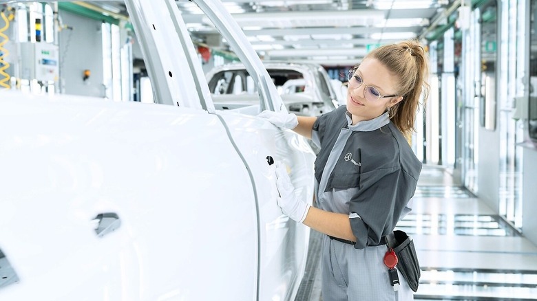 Woman inspecting paint at Mercedes-Benz factory