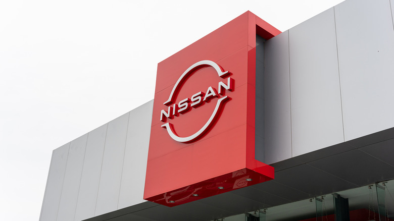 A Nissan logo in front of a dealership building