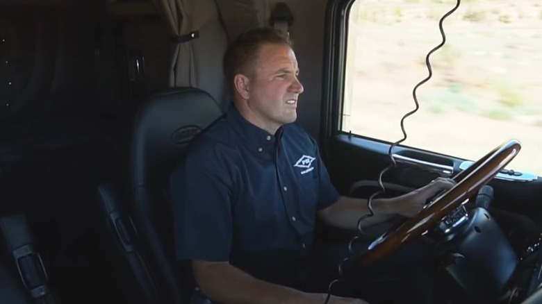 PDI Diesel CEO Jerad Wittwer smiling while driving a semi-truck.