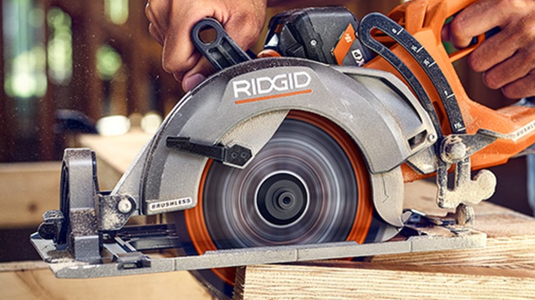 A person using a Ridgid circular saw on wood.