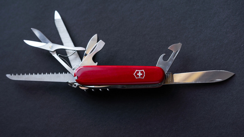 A Swiss army knife sitting open on a table.