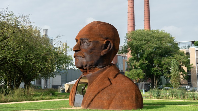 A large statue of Gerard Philips sits on grass in a park