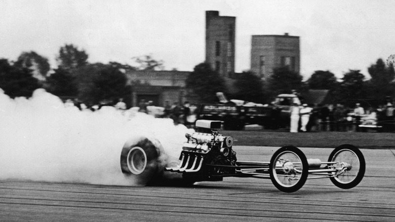 Mickey Thompson is obscured by a cloud of his own smoke while driving a Ford-powered dragster in England in 1964.