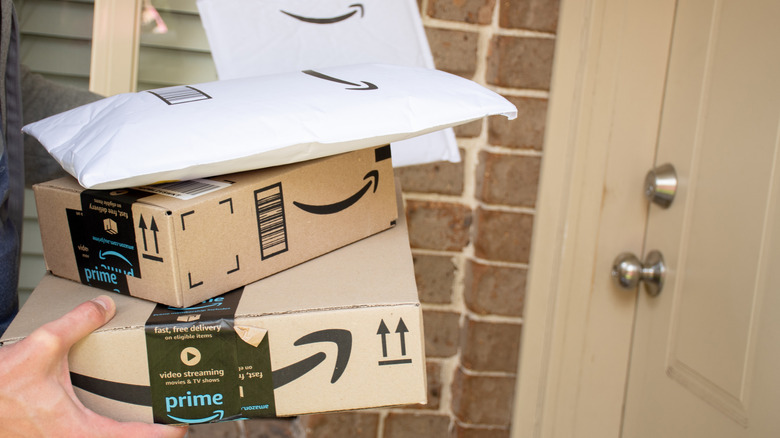 Person delivers stack of Amazon packages