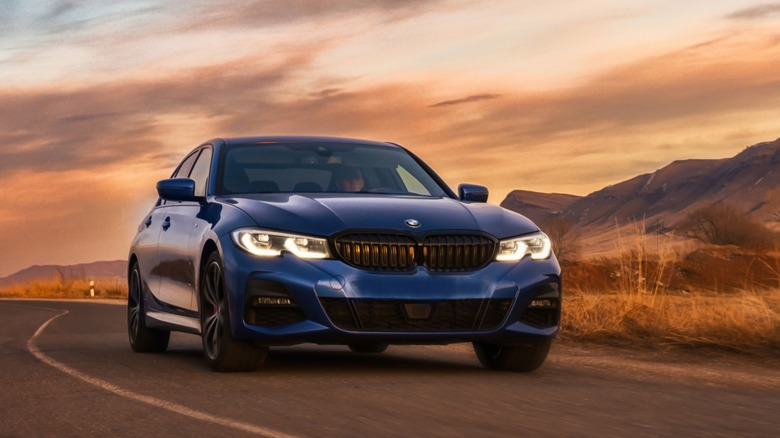 Blue BMW sedan driving during sunset