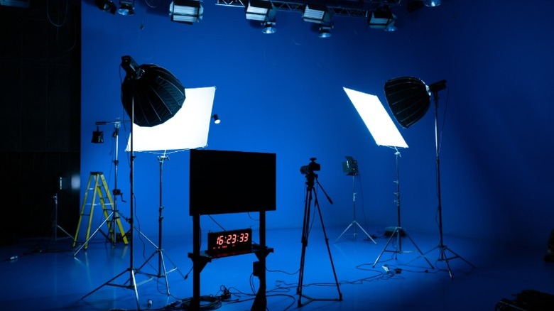 A professional filming set with blue screens set up around equipment