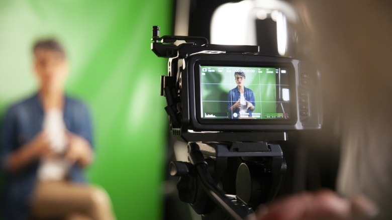 Person being recorded in front of a green screen