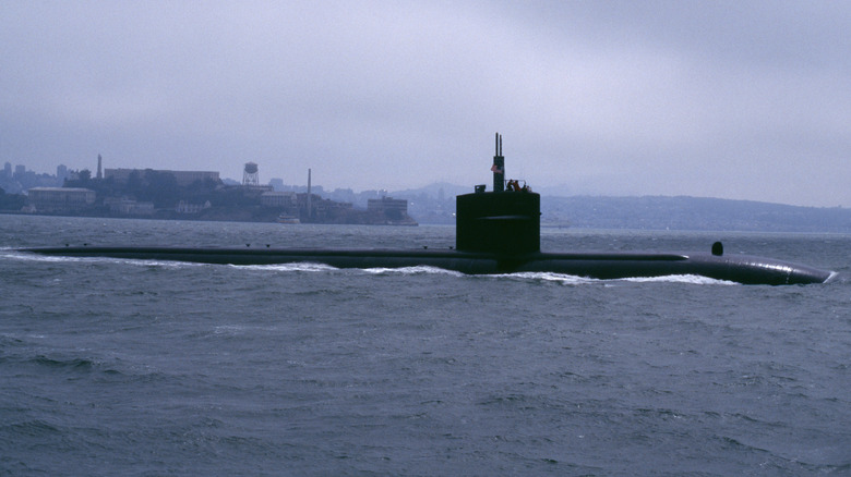 A submarine slipping out to sea under cover of fog