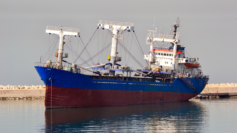 Large ship at dock with red hull