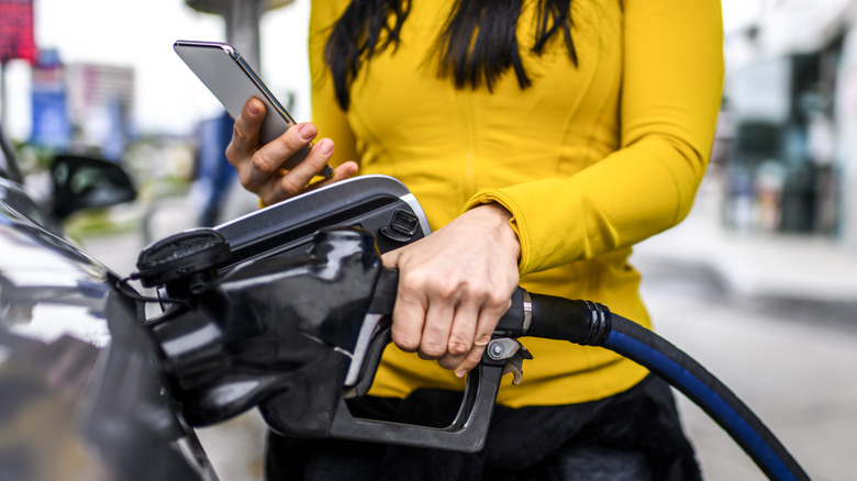 Looking at phone while pumping gas