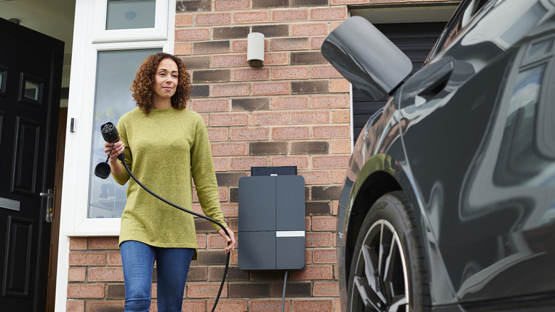 woman charging ev at home