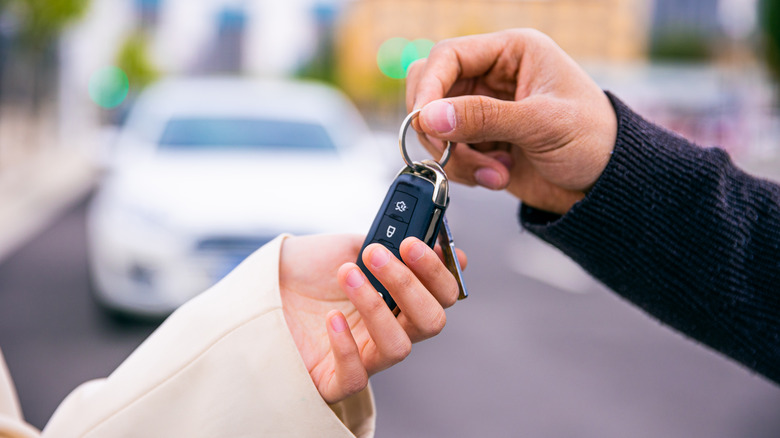 people exchanging car keys