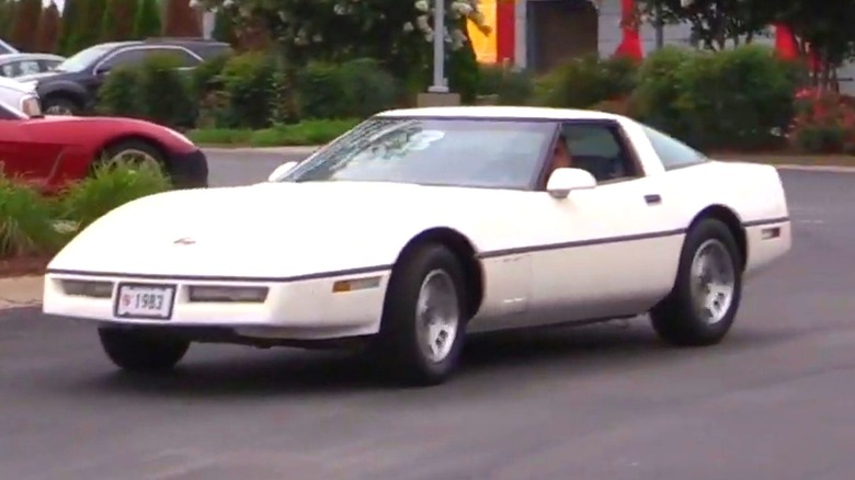 A white 1983 Chevrolet Corvette on a road.