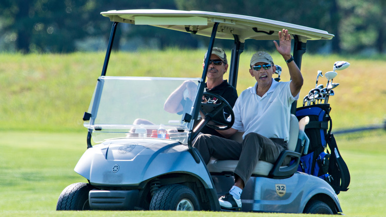 Former President Barack Obama driving a golf cart.