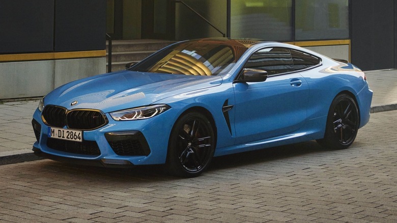 BMW M8 Competition Coupe parked on a paved surface in front of a building
