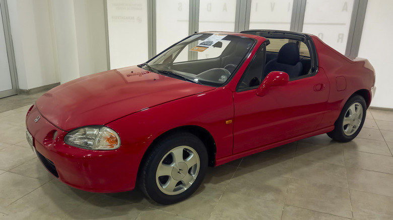 Red Honda Del Sol parked in showroom