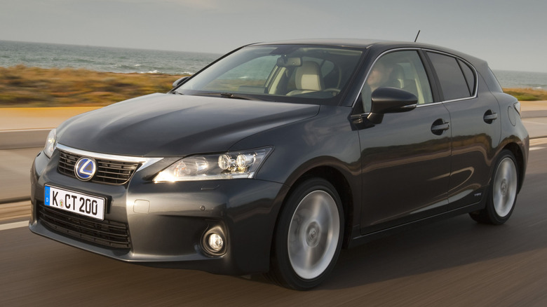 A gray Lexus CT200h is driven down a coastline.