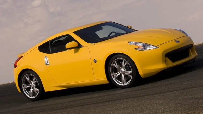 Yellow 2009 Nissan 370z Coupe parked on a pavement with sky background