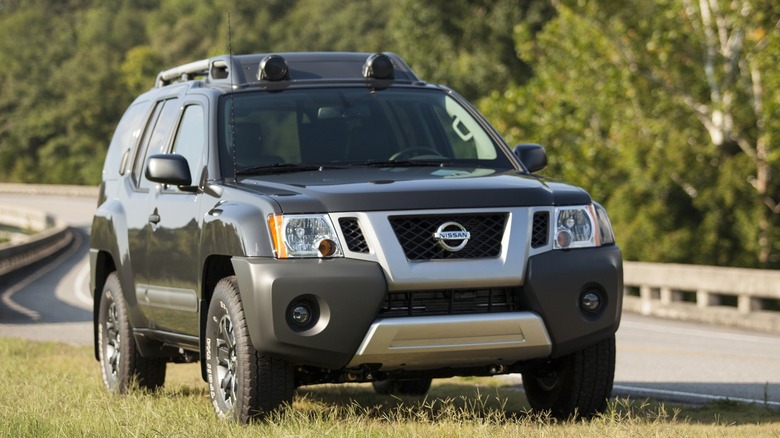 A 2015 Nissan Xterra parked in the grass on the roadside.