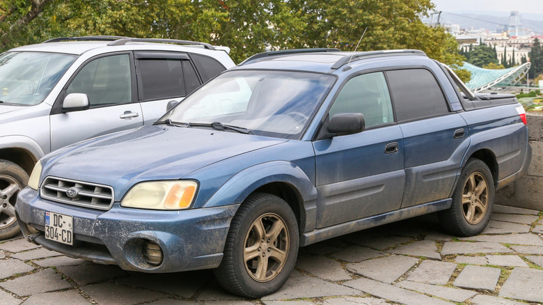 A blue Subaru Baja parked on a street