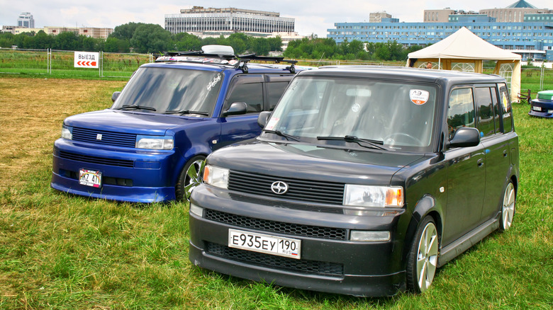 blue and black Scion xBs parked side-by-side in grass