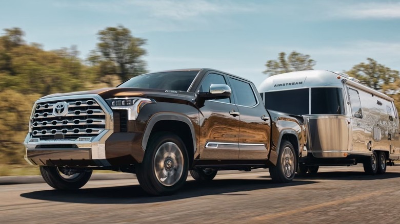 A 2025 Toyota Tundra towing a camper trailer.