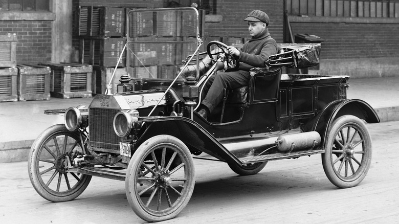 Person driving Ford Model T automobile