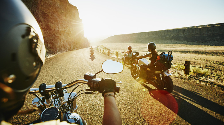 Group of female friends on motorcycle road trip on summer evening