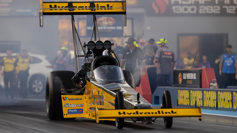 black and yellow drag race car making run on track