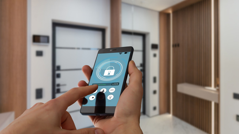 A person adjusts the settings of their smart home appliances using their cellphone