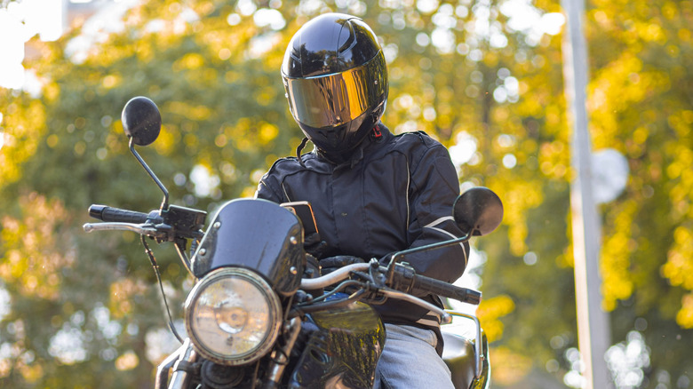 A motorcycle rider checking their phone.