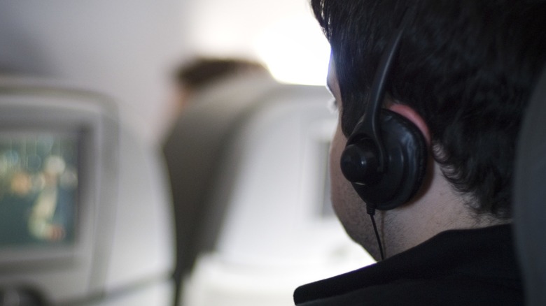 Close up shot of a traveler wearing headphones on a plane