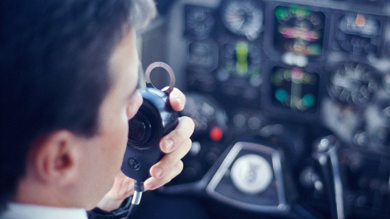 Pilot on radio in the cockpit of passenger plane