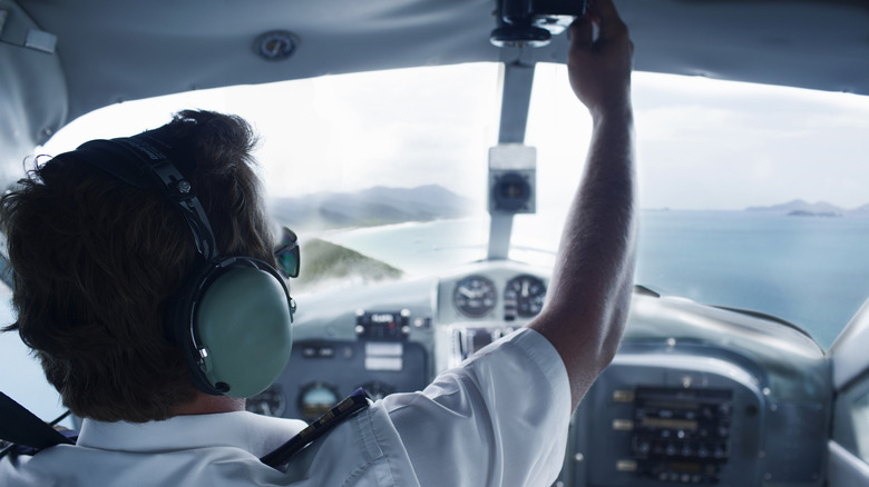 Pilot flipping switches in cockpit