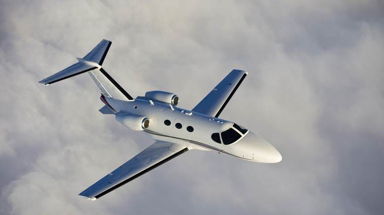 Private jet flying above the clouds