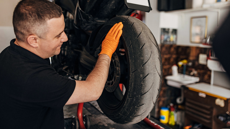 Mechanic checking motorcycle wheel