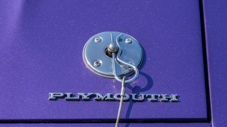 Close-up of a hood pin on a purple Plymouth.