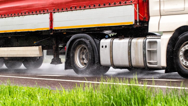 Close-up of semi tires driving on wet road