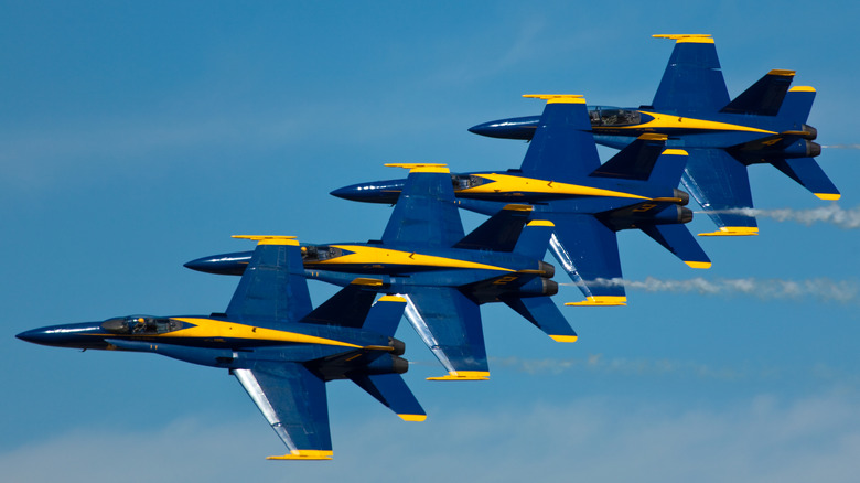 Four Blue Angels jets flying in close formation.