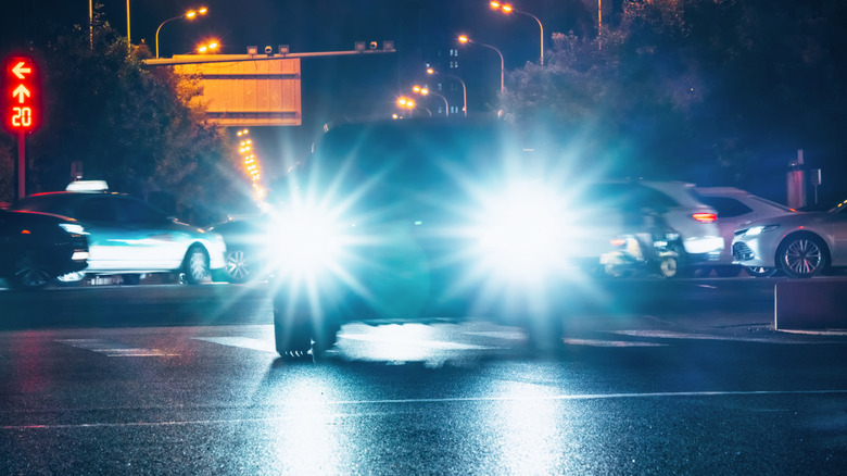 A car driving with LED headlights turned on.