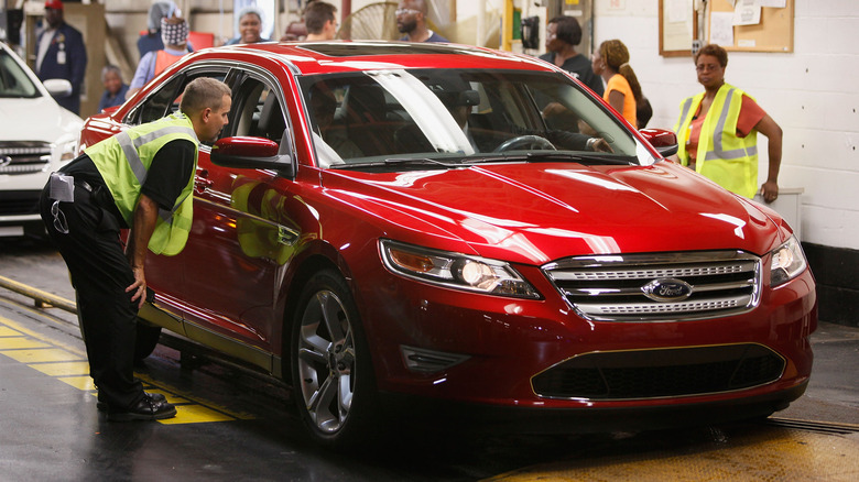 Workers inspecting Ford Taurus assembly line