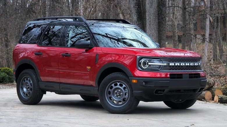 Ford Bronco Sport in red on a cemented patchway with woods in the background 
