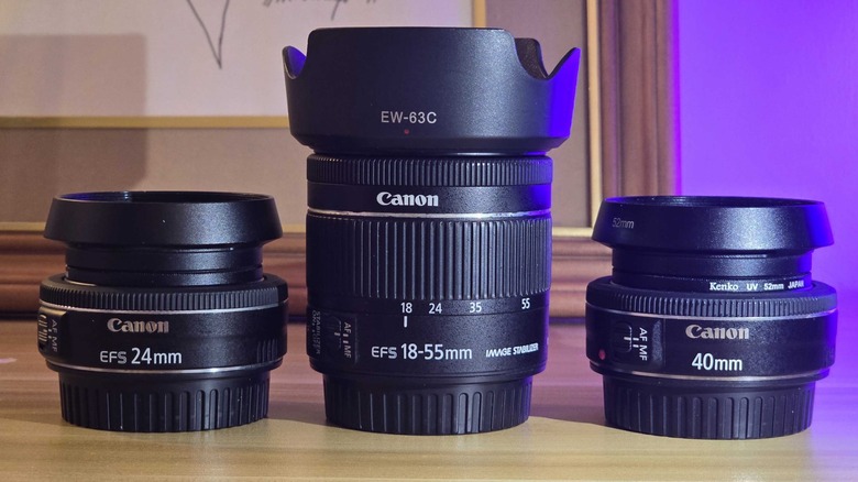 three canon camera lenses vertically on table