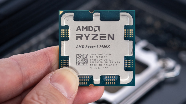 Fingers holding AMD Ryzen 7950X CPU