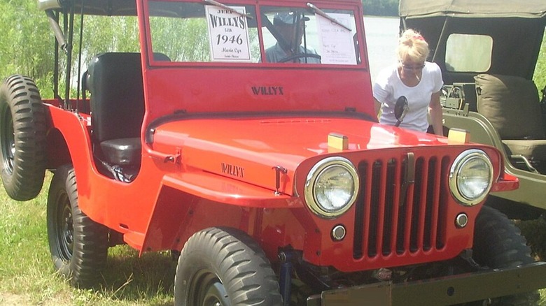 A red 1946 Jeep CJ parked on grass.