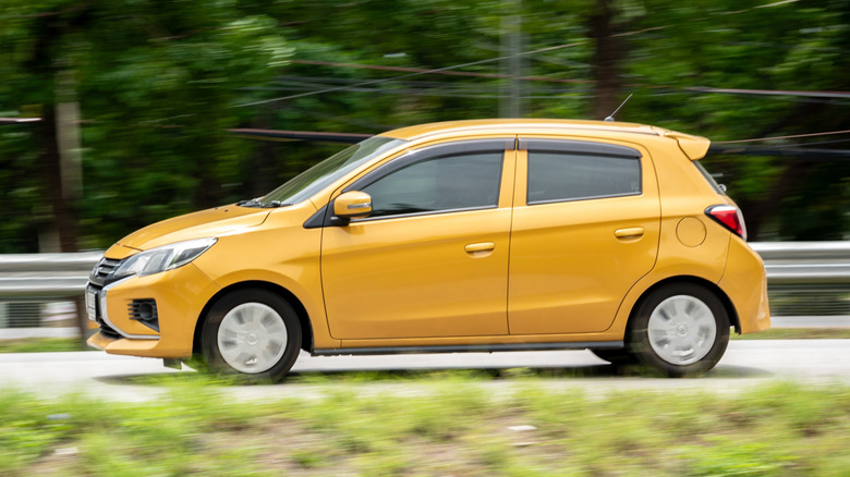 Yellow Mitsubishi Mirage on country road