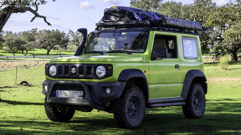 A green Suzuki Jimny in the countryside