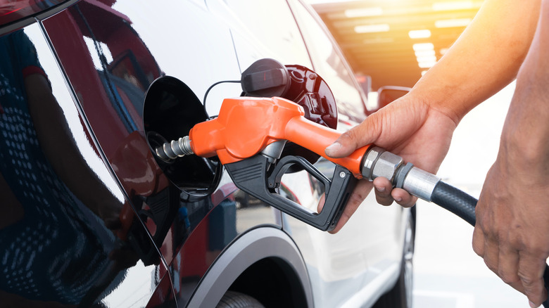 Hands shown pumping gas at gas station